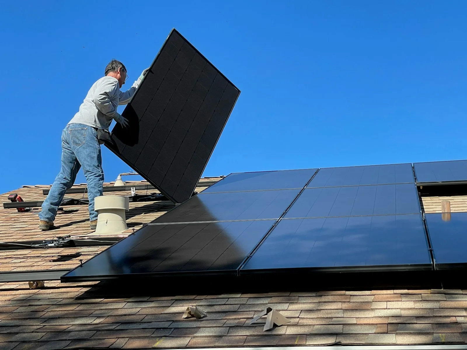 Tecnico al lavoro su un impianto fotovoltaico sul tetto di un edificio